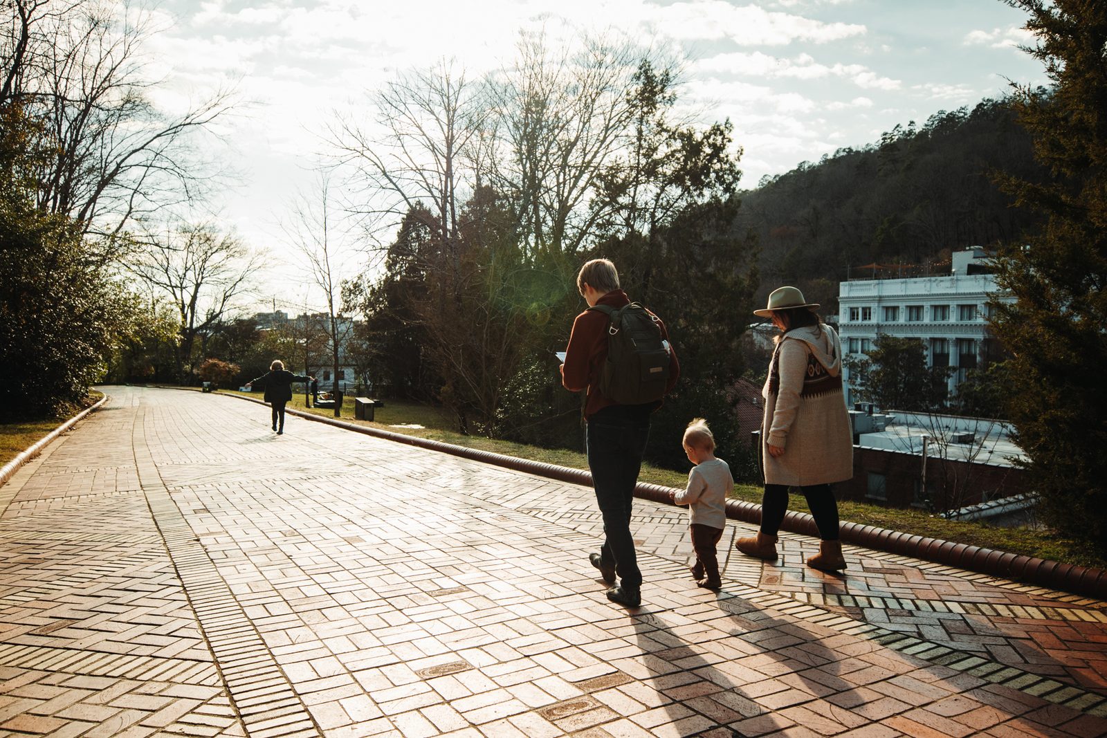 4 people walking down a brick pathway