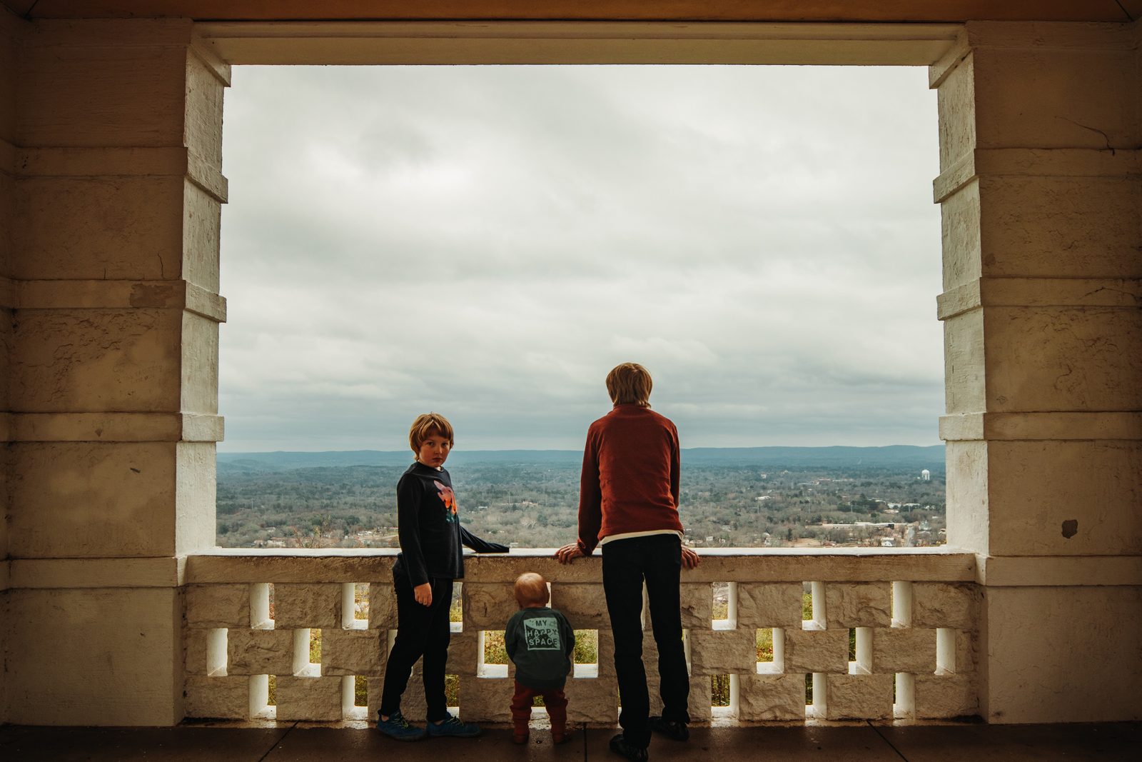 Three kids looking out over a scenic view